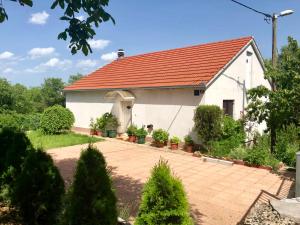 a small white house with a red roof at Holiday home Gudelj in Imotski