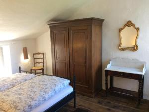 um quarto com uma cama, uma cómoda e um espelho em Casa Franceschi em Pioggiola