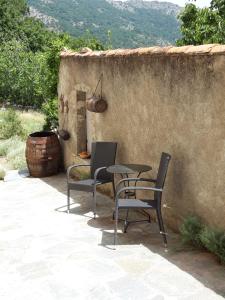a patio with two chairs and a table and a barrel at Casa Franceschi in Pioggiola +7 photos
