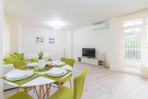 comedor con mesa y sillas verdes en Domus Apartments Grand en Plovdiv