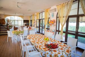jadalnia ze stołem i białymi krzesłami w obiekcie Il Dunnè w mieście Vittoria
