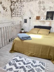 a bedroom with a bed with a yellow blanket and a rug at Le loft de cucuron in Cucuron