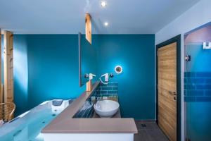 a blue bathroom with a tub and a sink at Infinity Blue Boutique Hotel & Spa - Adults Only in Hersonissos