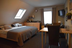- une chambre avec un lit, un bureau et une table dans l'établissement Effe-Zoutelande B&B, à Zoutelande