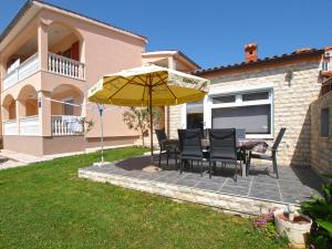 une terrasse avec une table, des chaises et un parasol dans l'établissement Apartments Ivanka 934, à Fažana