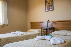Habitación de hotel con 2 camas y toallas. en Aguilas de Piedra en Cacheuta