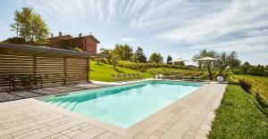 una piscina en un patio junto a una casa en Agriturismo l'Uva e le Stelle, en Faedis