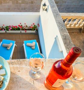 a bottle of wine sitting on a table with glasses at Kharmen A 1565s House with Seaviews in Birgu