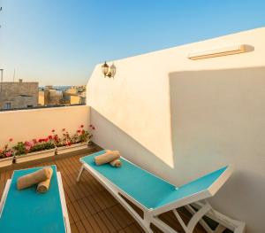 a balcony with two blue benches on a building at Kharmen A 1565s House with Seaviews in Birgu