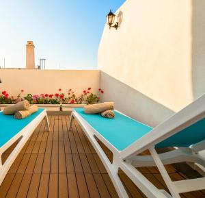 a balcony with two benches and some flowers at Kharmen A 1565s House with Seaviews in Birgu