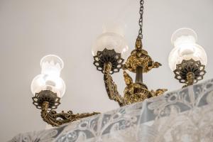 a chandelier with four lights on a wall at Kharmen A 1565s House with Seaviews in Birgu