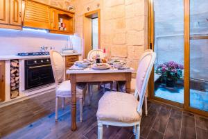 a kitchen with a table and chairs in a room at Kharmen A 1565s House with Seaviews in Birgu