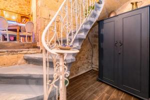 Cette chambre est dotée d'un escalier et d'une porte noire. dans l'établissement Kharmen A 1565s House with Seaviews, à Il-Birgu