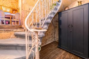 a room with a staircase and a black door at Kharmen A 1565s House with Seaviews in Birgu +37 photos