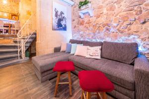 a living room with a couch and two red stools at Kharmen A 1565s House with Seaviews in Birgu