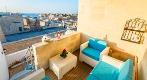 a balcony with chairs and a view of the city at Kharmen A 1565s House with Seaviews in Birgu