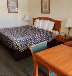 a hotel room with a bed and a table at Express Inn & Suites Westwego in Westwego