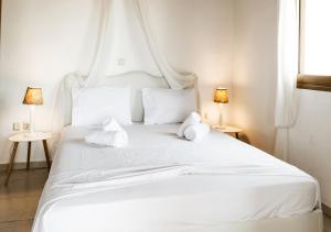 a white bed with two white pillows on it at Sanidiamonds in Sani Beach