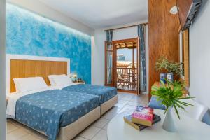 um quarto com uma cama e uma varanda em Aeolos Hotel em Skopelos