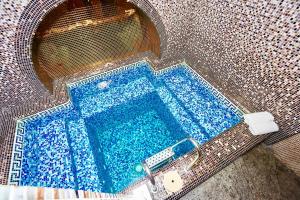 a swimming pool in a building with blue tiles at Apartment Grecheskie in Odesa