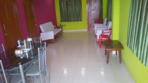 ein Esszimmer mit farbenfrohen Wänden, Tischen und Stühlen in der Unterkunft Roxel Inn in Port Blair