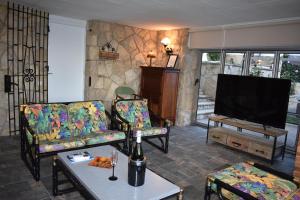 a living room with two chairs and a flat screen tv at VILLA GARDEN in Tarragona