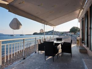 a table and chairs on a balcony overlooking the ocean at Alexis Studios in Finikounta