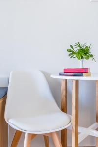 a white chair next to a table with a plant at Aeolos Hotel in Skopelos Town