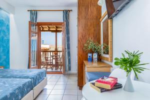 a bedroom with a bed and a table and a balcony at Aeolos Hotel in Skopelos Town