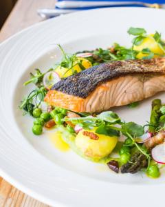 a plate of food with fish and vegetables on it at The Randolph Hotel in Southwold