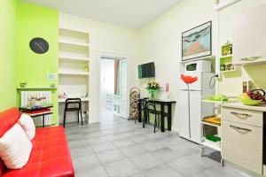 kuchnia i salon z czerwoną kanapą w obiekcie Cenisio & Sempione Cosy Flat w Mediolanie