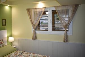 a bedroom with a window with curtains and a bed at VILLA GARDEN in Tarragona