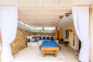 una mesa de ping pong en medio de un patio en Elmyra Villa, Heated Pool & Walking to beach, By ThinkVilla, en Gerani