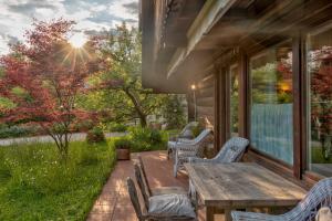 eine Terrasse mit einem Holztisch und Stühlen auf einem Haus in der Unterkunft Bajtica Guesthouse in Bled