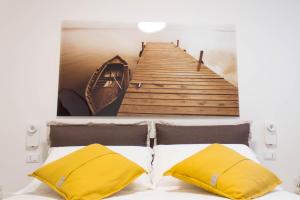 a picture of a pier and a bed with yellow pillows at Casa Felice in Savelletri di Fasano