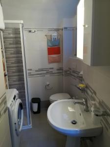 bagno con lavandino bianco e servizi igienici di Casetta nel Borgo a Monasterace