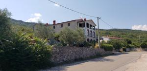 ein Haus auf einem Hügel mit einer Steinmauer in der Unterkunft VILLA DIVNA in Labin