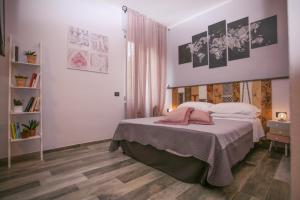 ラ・スペツィアにあるCIVICO 69 AFFITTACAMEREのベッドルーム1室(ベッド1台付)が備わります。壁には絵画が飾られています。