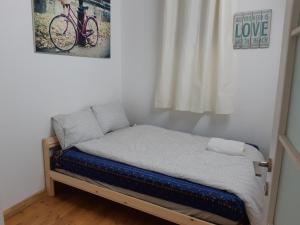 ein kleines Bett in einem Zimmer mit Fahrrad an der Wand in der Unterkunft BE ME Hotels and Hostels HAIFA ART in Haifa