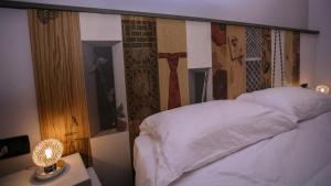 ein Schlafzimmer mit einem Bett mit einem Kopfteil mit Avertisation in der Unterkunft CIVICO 69 AFFITTACAMERE in La Spezia