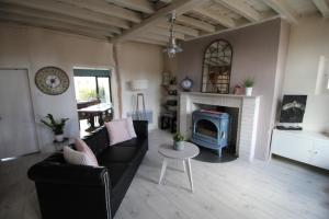 uma sala de estar com um sofá e uma lareira em Maison IZARO em Précy-Saint-Martin