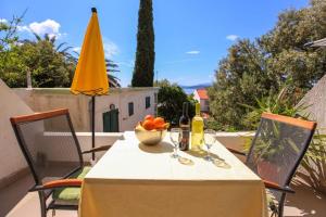 a table with a bowl of fruit and a yellow umbrella at Apartments Toni Two in Igrane