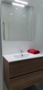a bathroom sink with a mirror and a red towel at Tanger -Madina in Tangier