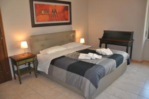 カターニアにあるPuccini apartmentのベッドルーム1室(ベッド1台、テーブル2台、ピアノ付)