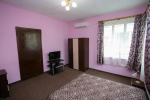 a bedroom with pink walls and a bed and a window at Guest House Dobrudzha in Gabrovo