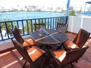 una mesa y sillas en un balcón con vistas al océano en CASA del CHARCO 2,0, en Arrecife