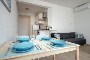 a dining room table with blue bowls and plates on it at Sunrise Apartments Bol in Bol