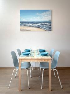 a dining room table with chairs and a painting at Sunrise Apartments Bol in Bol