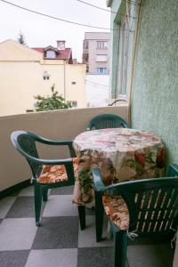 a table and chairs on a balcony with a window at Guest House Dobrudzha in Gabrovo