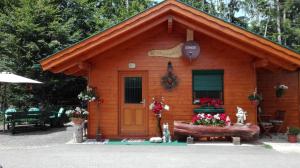 eine kleine Holzhütte mit einer Tür und Blumen in der Unterkunft Ferienhaus Barbara in Ebenthal